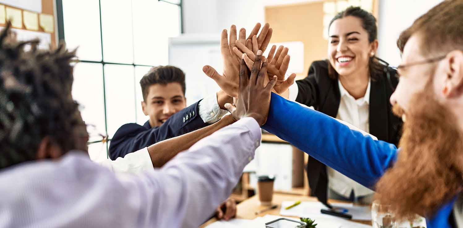 4 WEG-Verwalter treffen sich mit Ihren Händen über einem Tisch